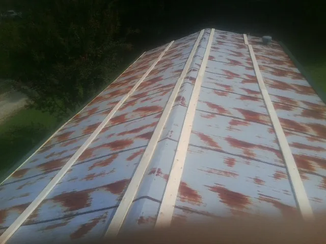 Rusted metal roof panels with new wood purlins before replacement — Storm Damage Roof Repair in Turners Falls by Roofing Brothers