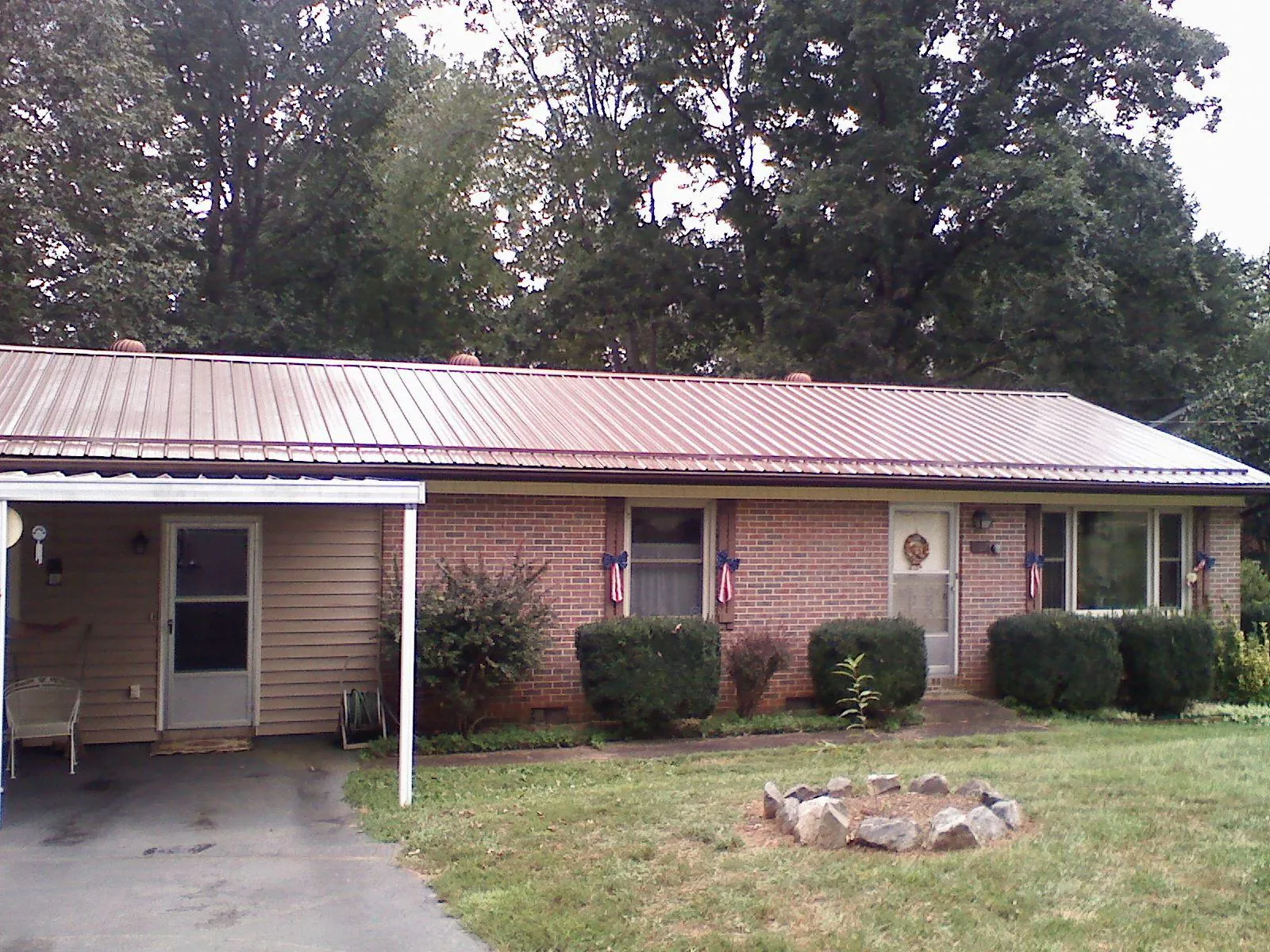 Bronze metal roof and carport on a brick ranch home — Roof Repair work by our crew in Turners Falls